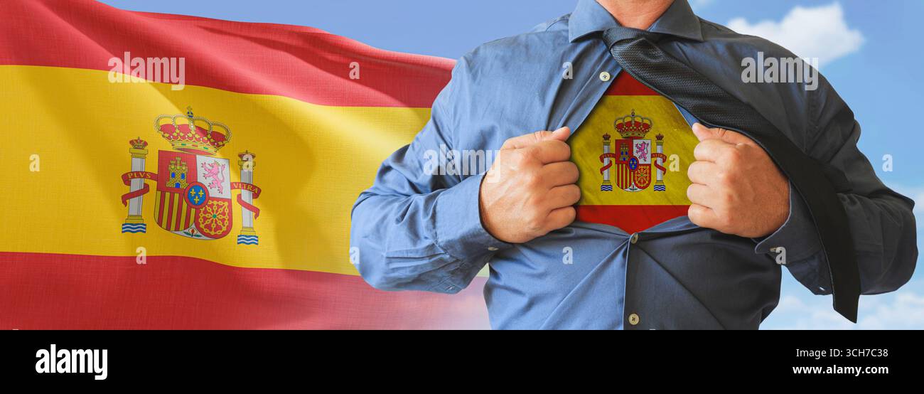 A businessman opening his shirt like super hero with Spain flag and shows how patriotic he is by revealing his countries flag beneath printed on a t-s Stock Photo