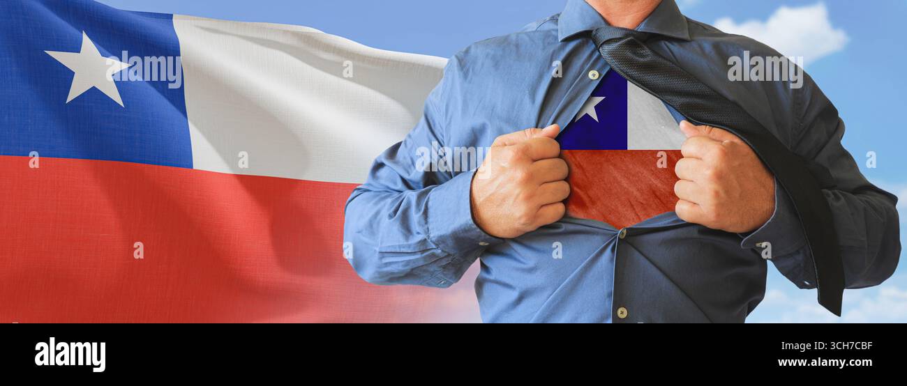 A businessman opening his shirt like super hero with Chile flag and shows how patriotic he is by revealing his countries flag beneath printed on a t-s Stock Photo