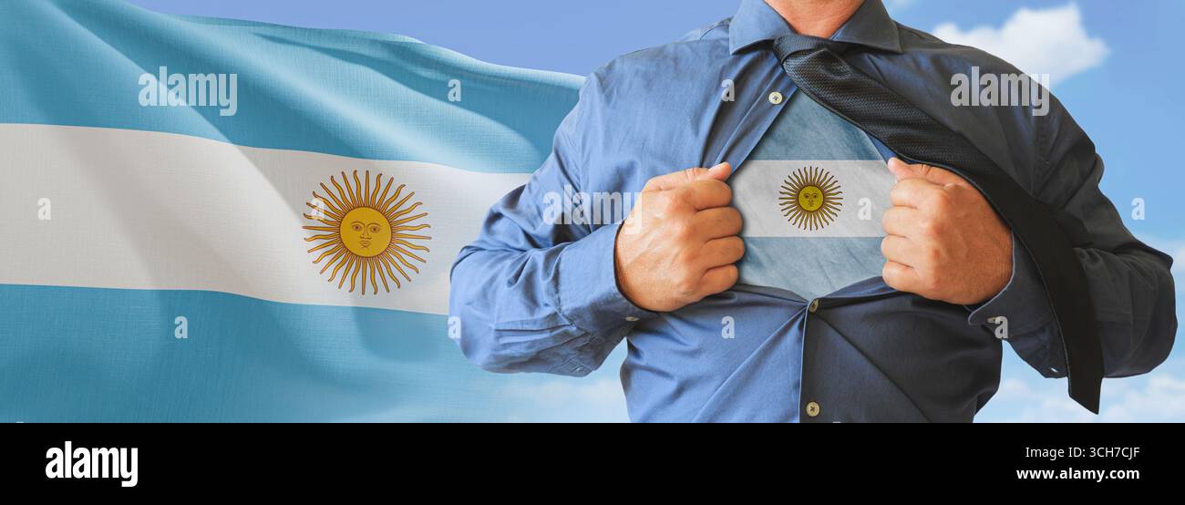 A businessman opening his shirt like super hero with Argentina flag and shows how patriotic he is by revealing his countries flag beneath printed on a Stock Photo