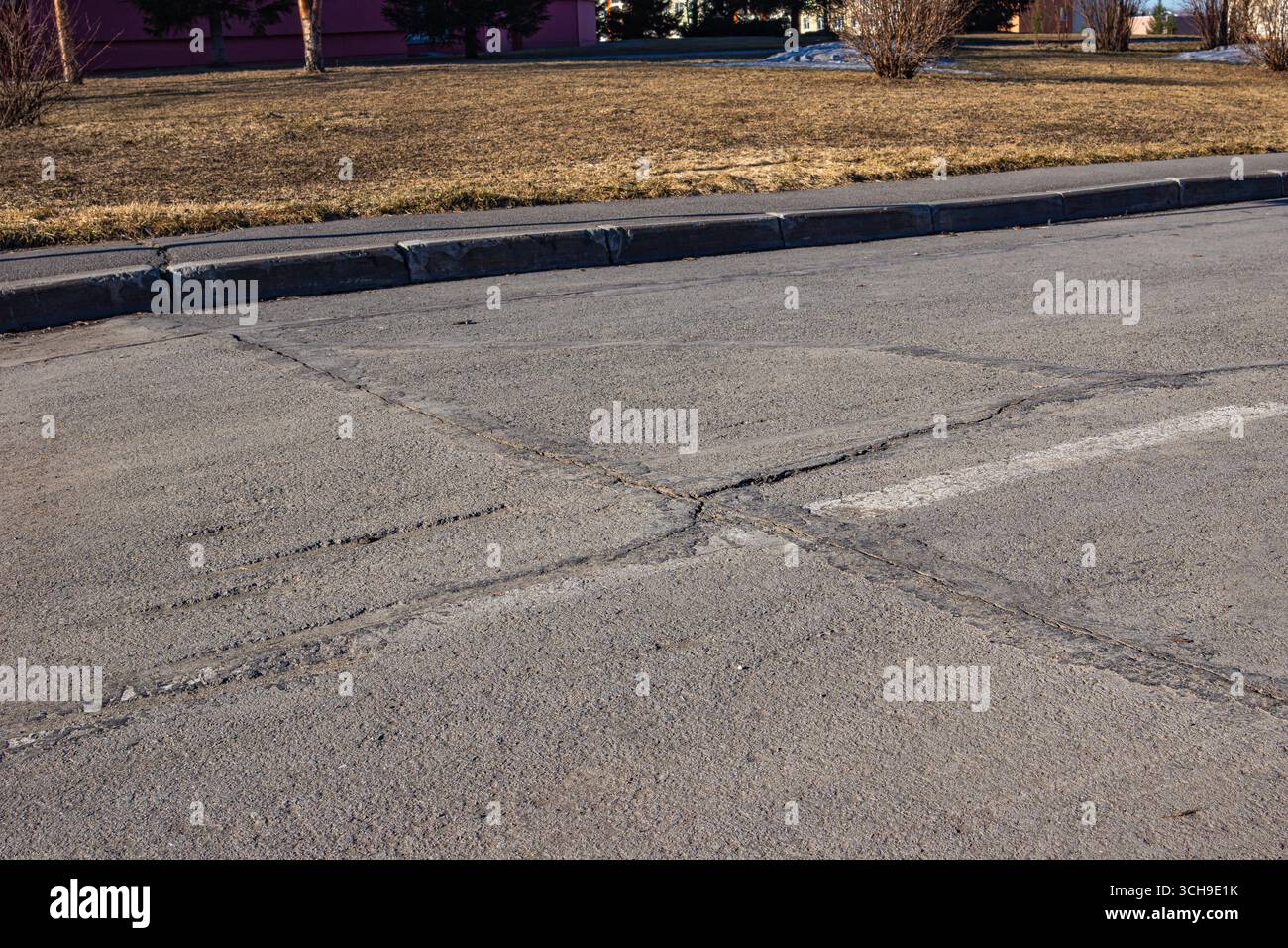 A cracked asphalt surface representing systemic failures in urban development, poor oversight, and long-term consequences of inadequate planning with Stock Photo