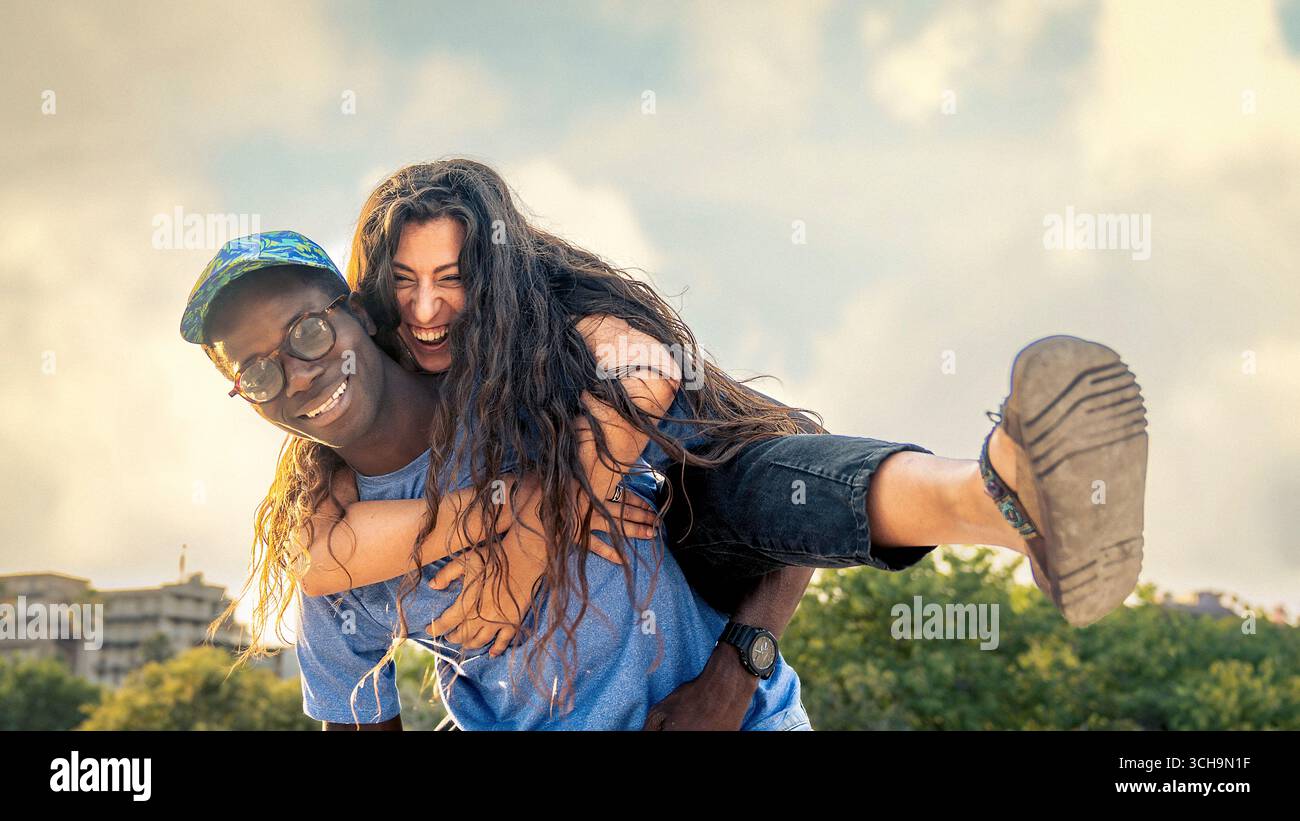 Happy multicultural couple having fun outdoors on a sunny summer day ...