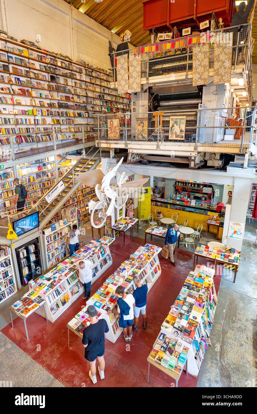 Bookstore Ler Devagar in Lisbon’s LX Factory, a former newspaper print factory, now cultural hotspot, with books, vinyl records, historic machinery. Stock Photo