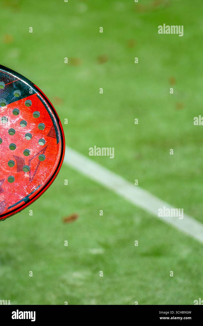Padel Racket View A close-up top-down view of a red padel racket on a green court in the ...