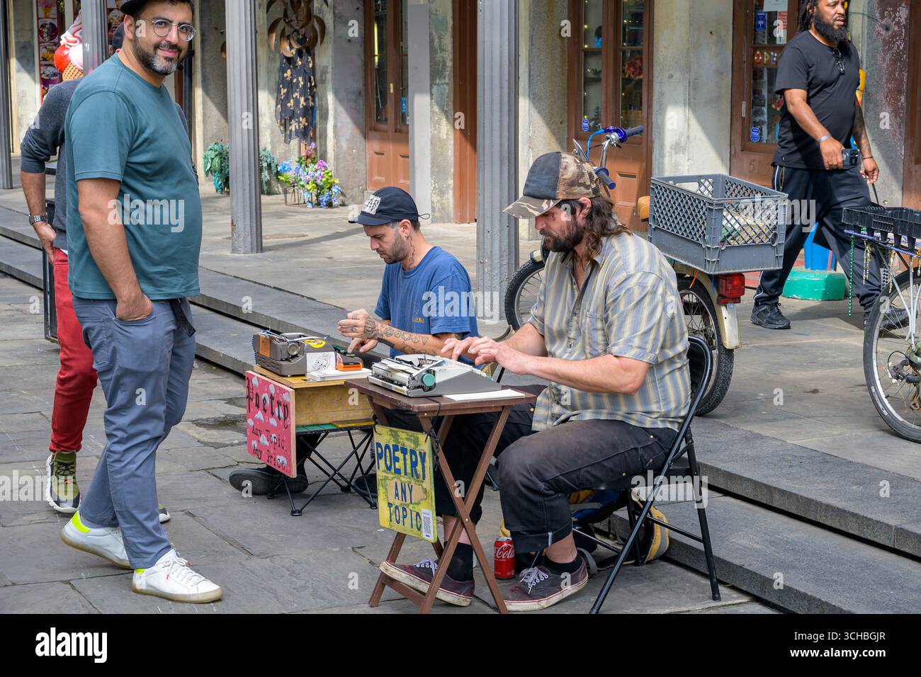 New Orleans, LA, USA - February 7, 2025: Two buskers typing street poems, for a price, for tourists next to Jackson Square in the French Quarter Stock Photo