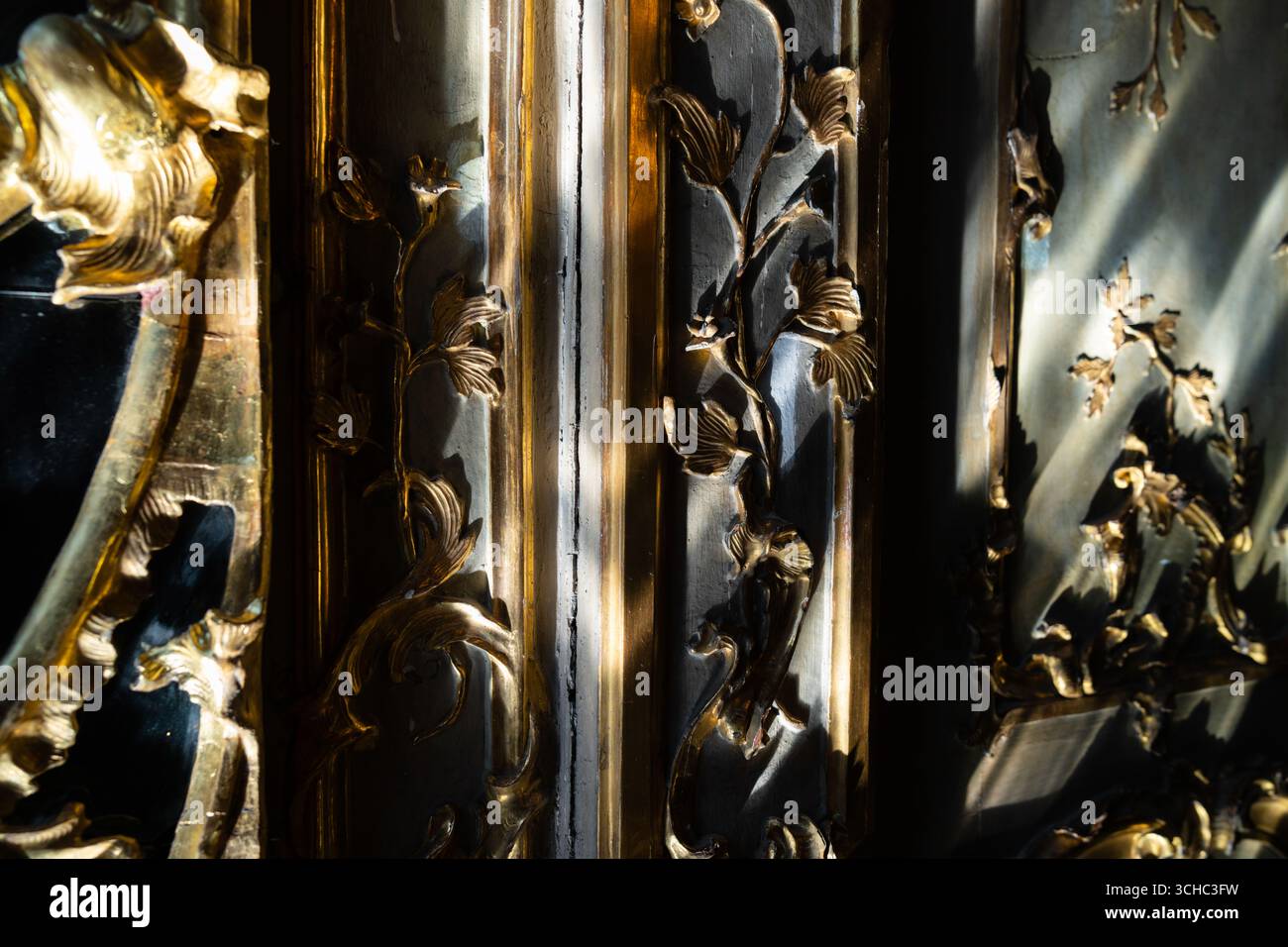 Milan, Italy - April, 11, 2025: Closeup of Baroque gold leaf ornamental frame detail with dramatic light and shadow, Palazzo Litta historic interior Stock Photo