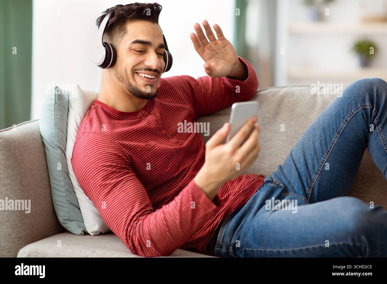 Cheerful arab guy having video chat, using mobile phone Stock Photo