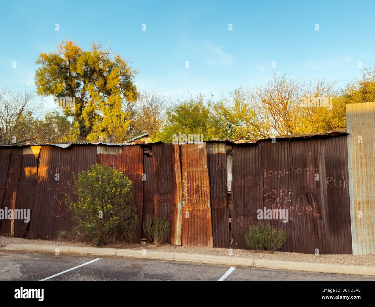 The iconic rusty, weathered corrugated metal fence is handmade, evoking resourcefulness and resilience in the harsh Southwest environment. - Smartphone Captured Stock Image