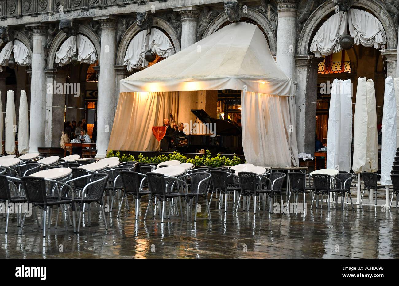 Historic Caffè Florian opened in 1720 in St Mark's Square, one of the oldest coffee house in the world, with musicians playing during a storm, Venice Stock Photo