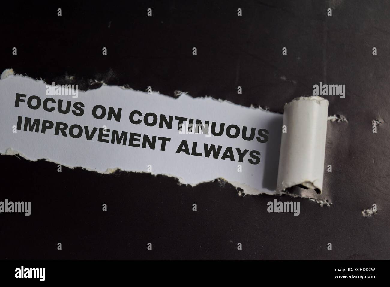Focus on continuous improvement always Text written in torn paper Stock Photo