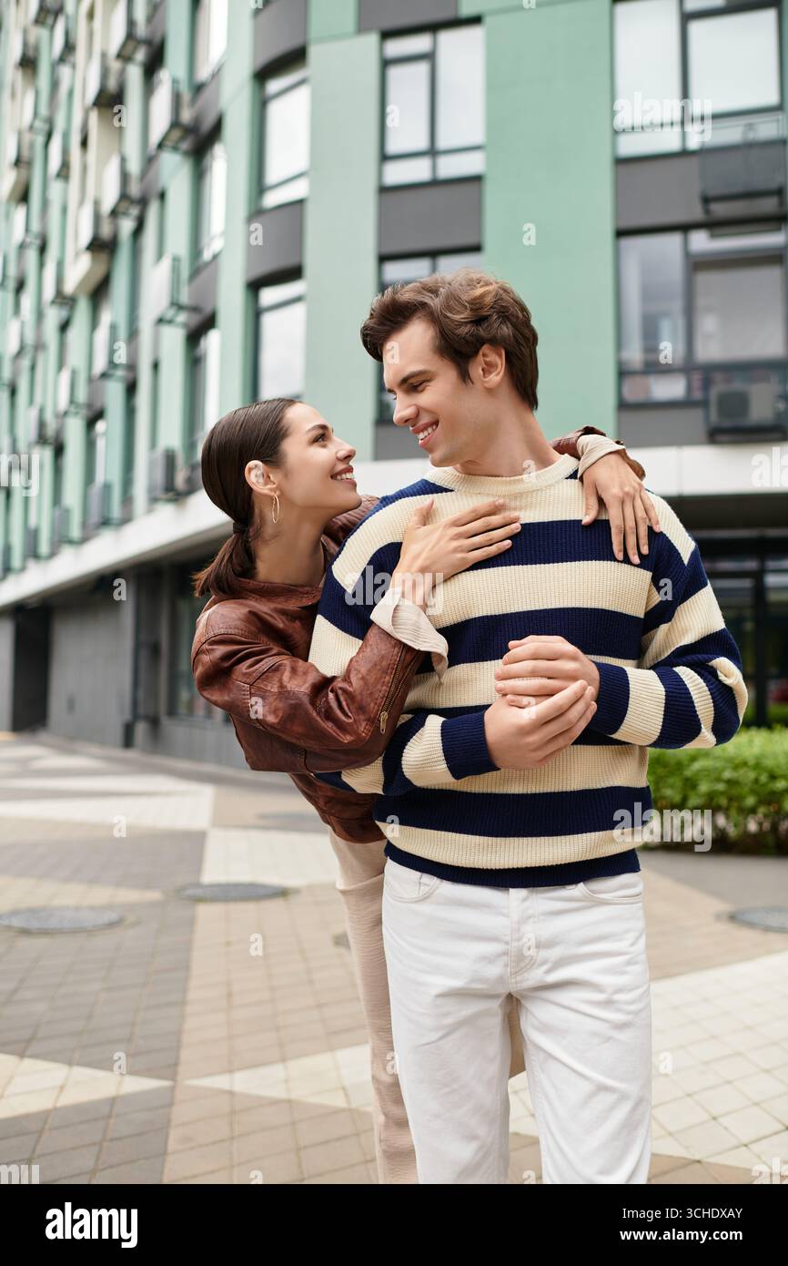 In a vibrant city environment, a loving couple shares a playful moment and embraces each other. Stock Photo
