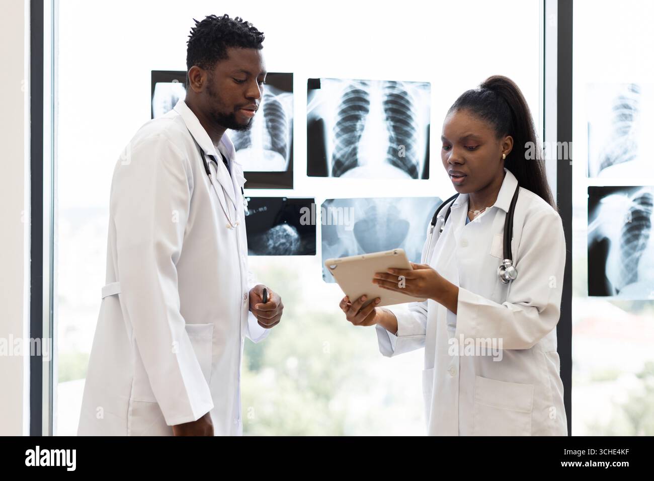 Medical professionals discussing patient case and reviewing x-rays ...