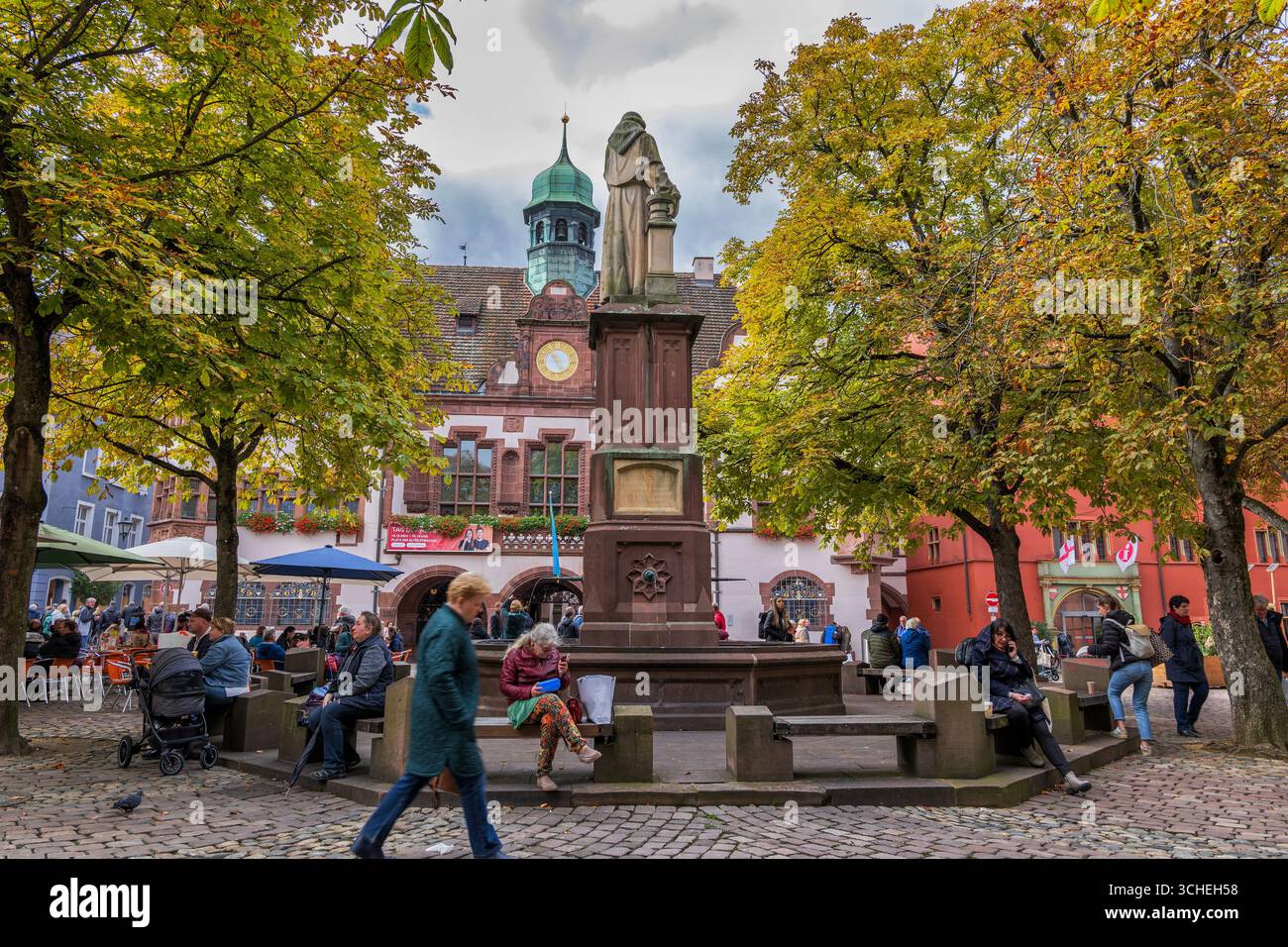 Freiburg im Breisgau, Germany - October 4, 2024: Berthold Schwarz Brunnenand monument and fountain on Rathausplatz square and Neues Rathaus - New Town Stock Photo