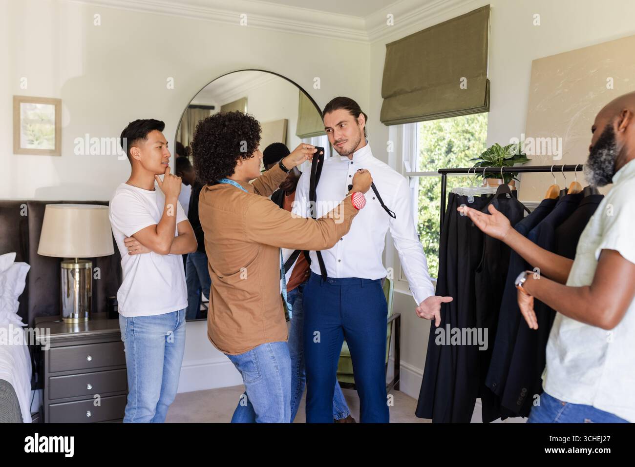 Dressing Client Fitting Diverse male styling team measuring client for suit in dressing ...