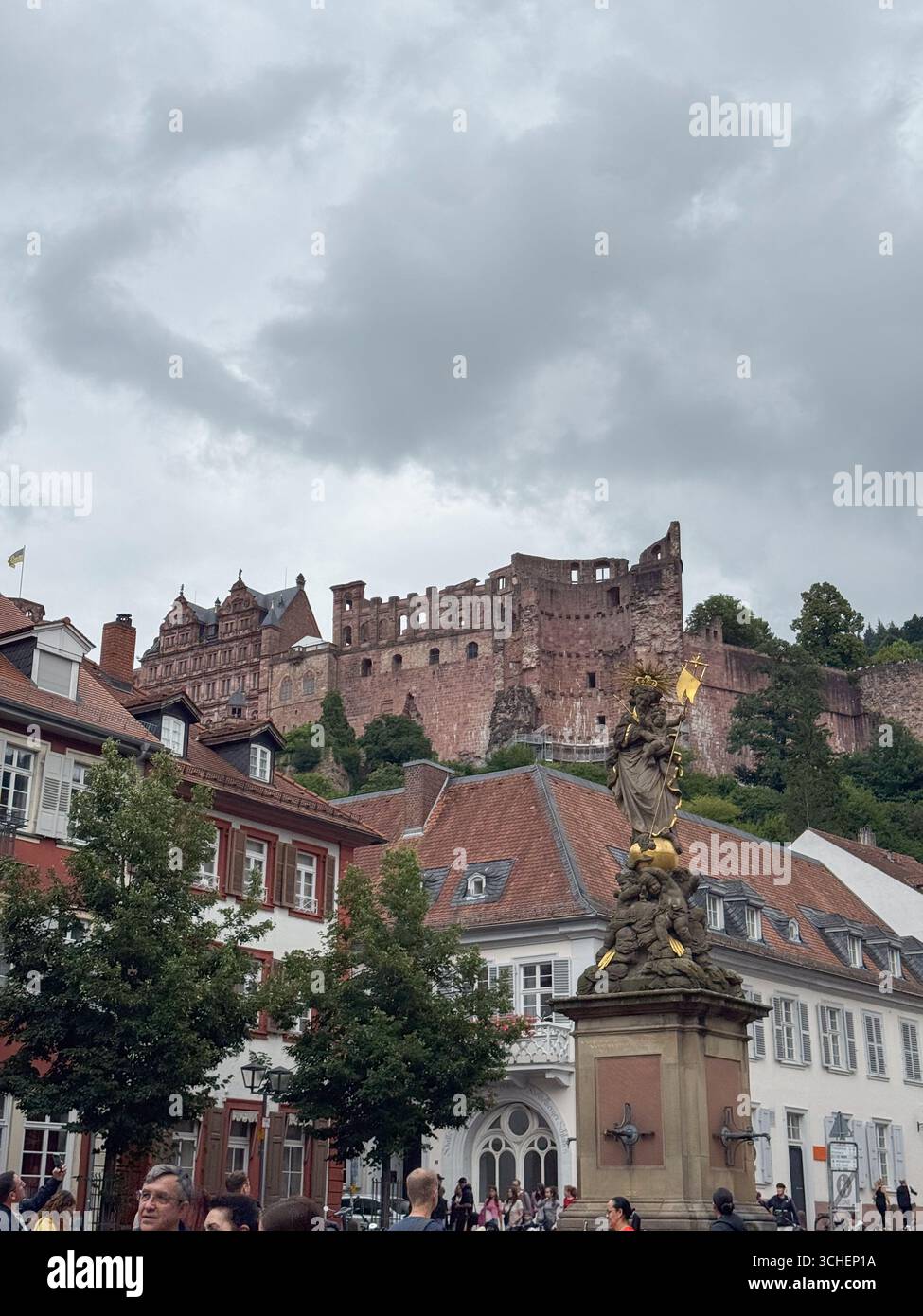 Crowded street scene in Heidelberg features the iconic medieval ...