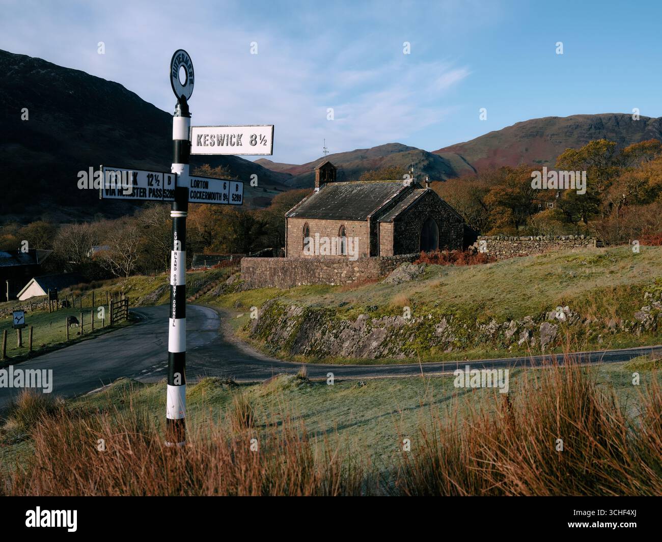 Signpost to Keswick and St James' Church in Buttermere village, Cumbria England UK Stock Photo
