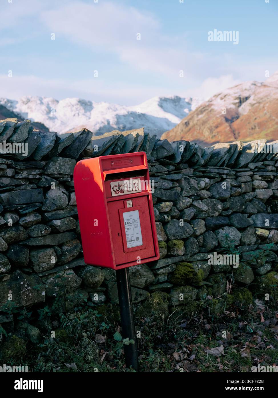 A red Royal Mail post box and dry stone wall in the winter Lake District landscape of the Langdales, Cumbria England UK Stock Photo