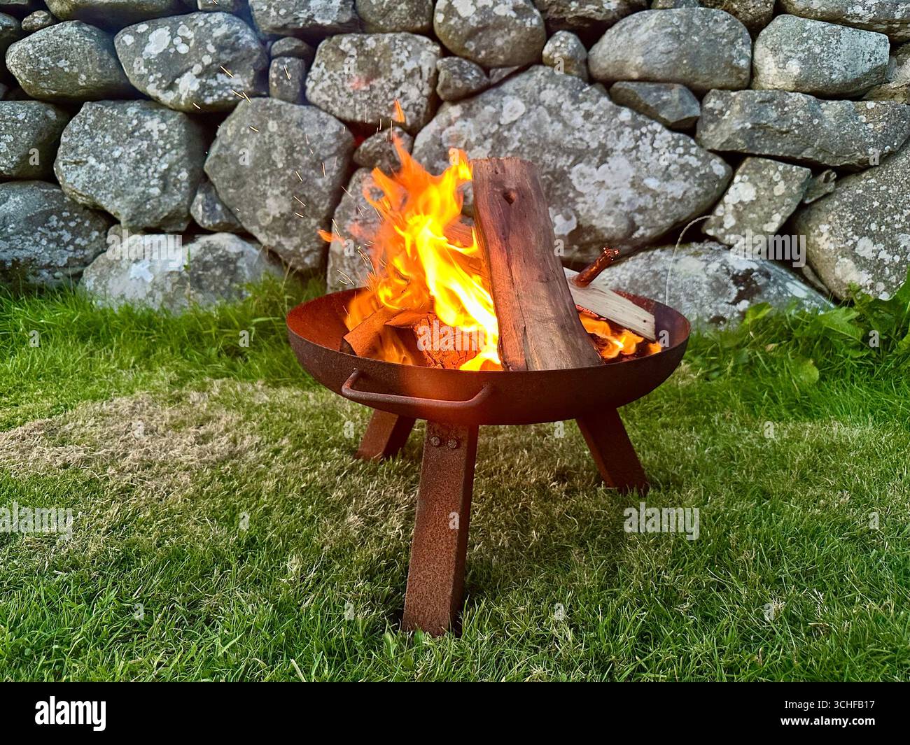 A campfire made of logs in a fire bowl - Smartphone Captured Stock Image