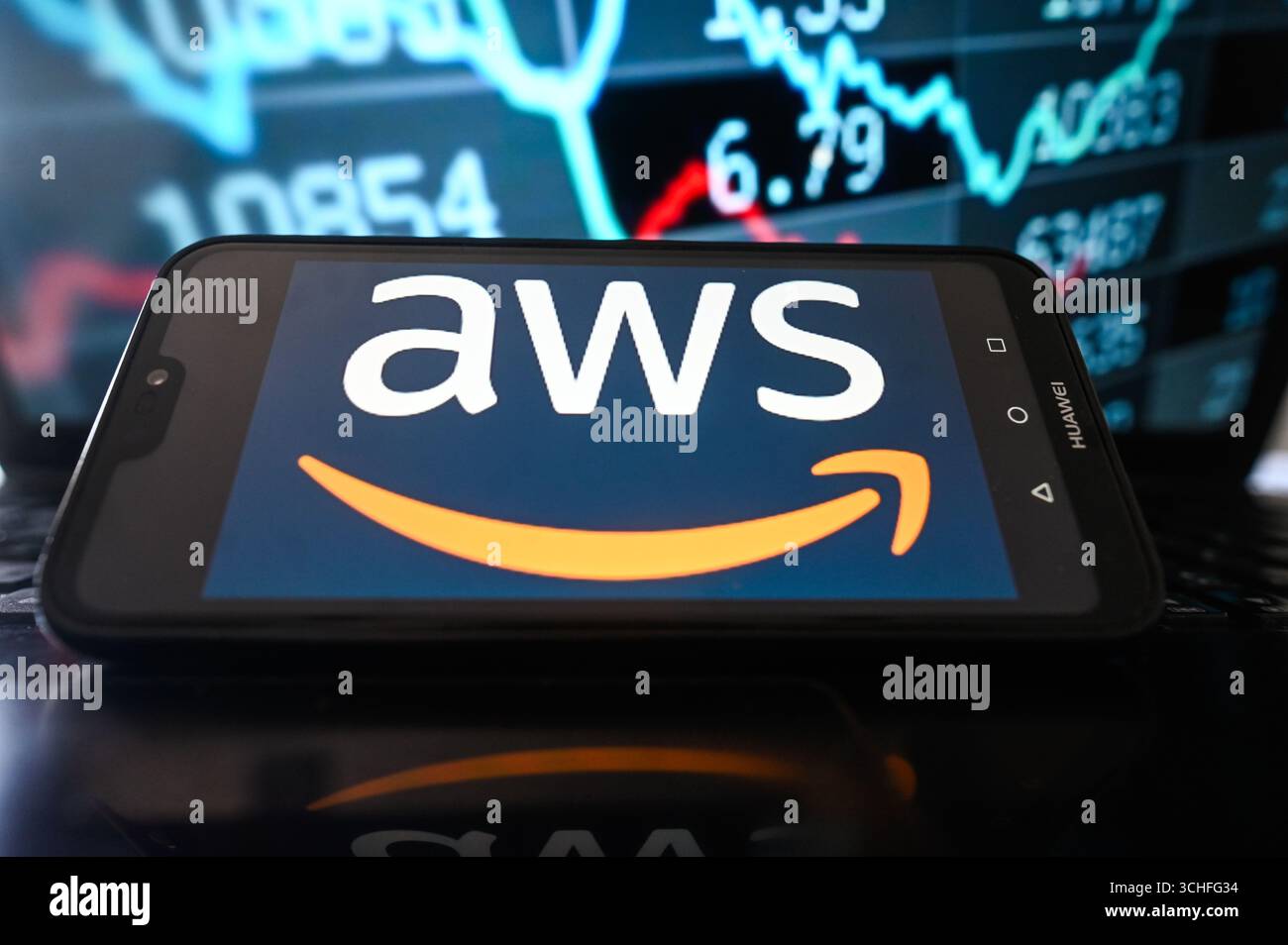 In this photo illustartion, an AWS logo is seen displayed on a smartphone with stock market percentages on the background. Stock Photo