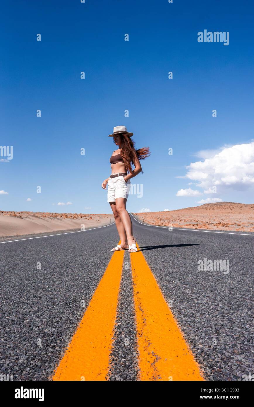 Woman Standing on Desert Highway with Sand Dunes in Nevada Stock Photo ...