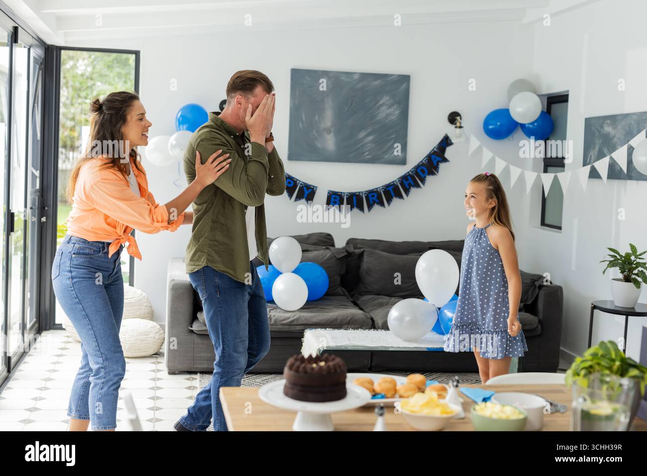 Family celebrating birthday surprise at home with balloons and cake — free download