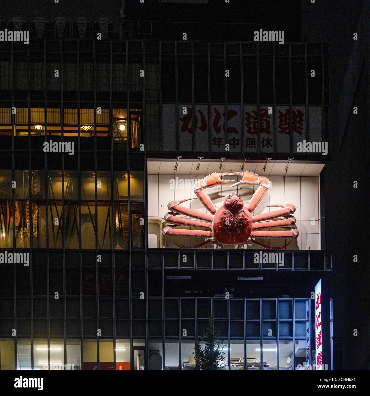 Giant crab decoration on the side of a building at niight in Shinjuku, Tokyo, August 2025 - Stock Image