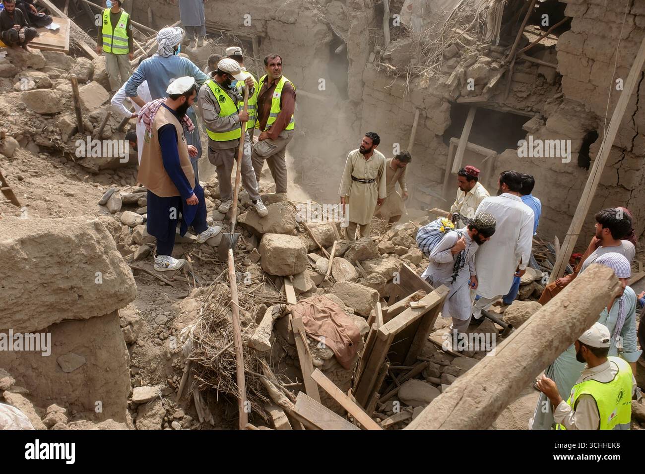 Civil defense workers, locals, and army soldiers clear rubble of a ...