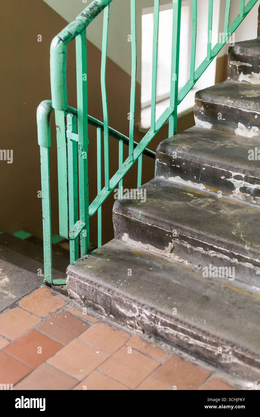 Stairs in a neglected building reveal peeling paint and worn-out steps ...