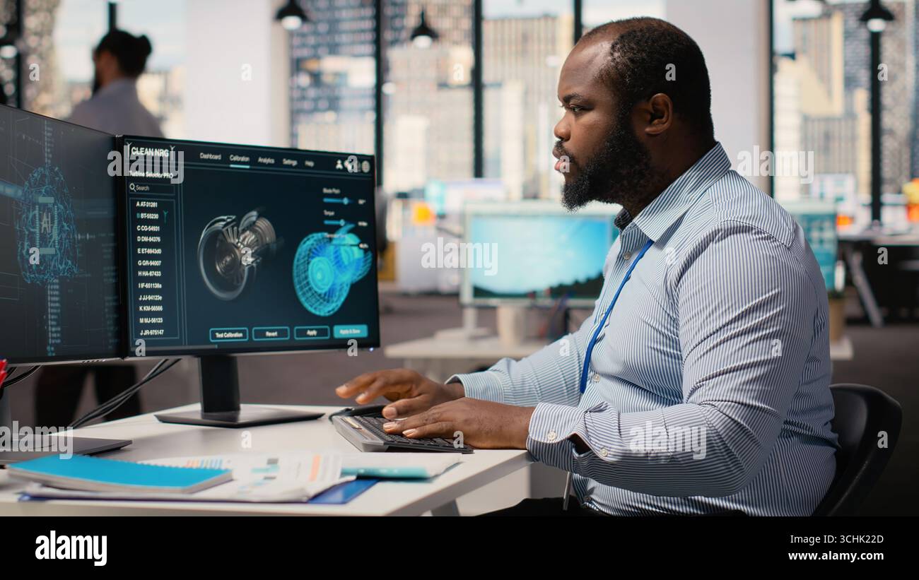 Engineer working on wind turbine simulation in office using artificial intelligence. RD department worker using AI tech and CAD program, doing renewable energy generation engineering, camera B Stock Photo