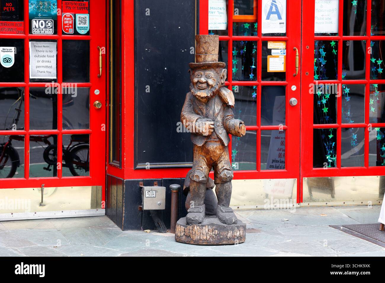 A carved wooden statue of a leprechaun outside an Irish bar in Manhattan, New York City Stock Photo