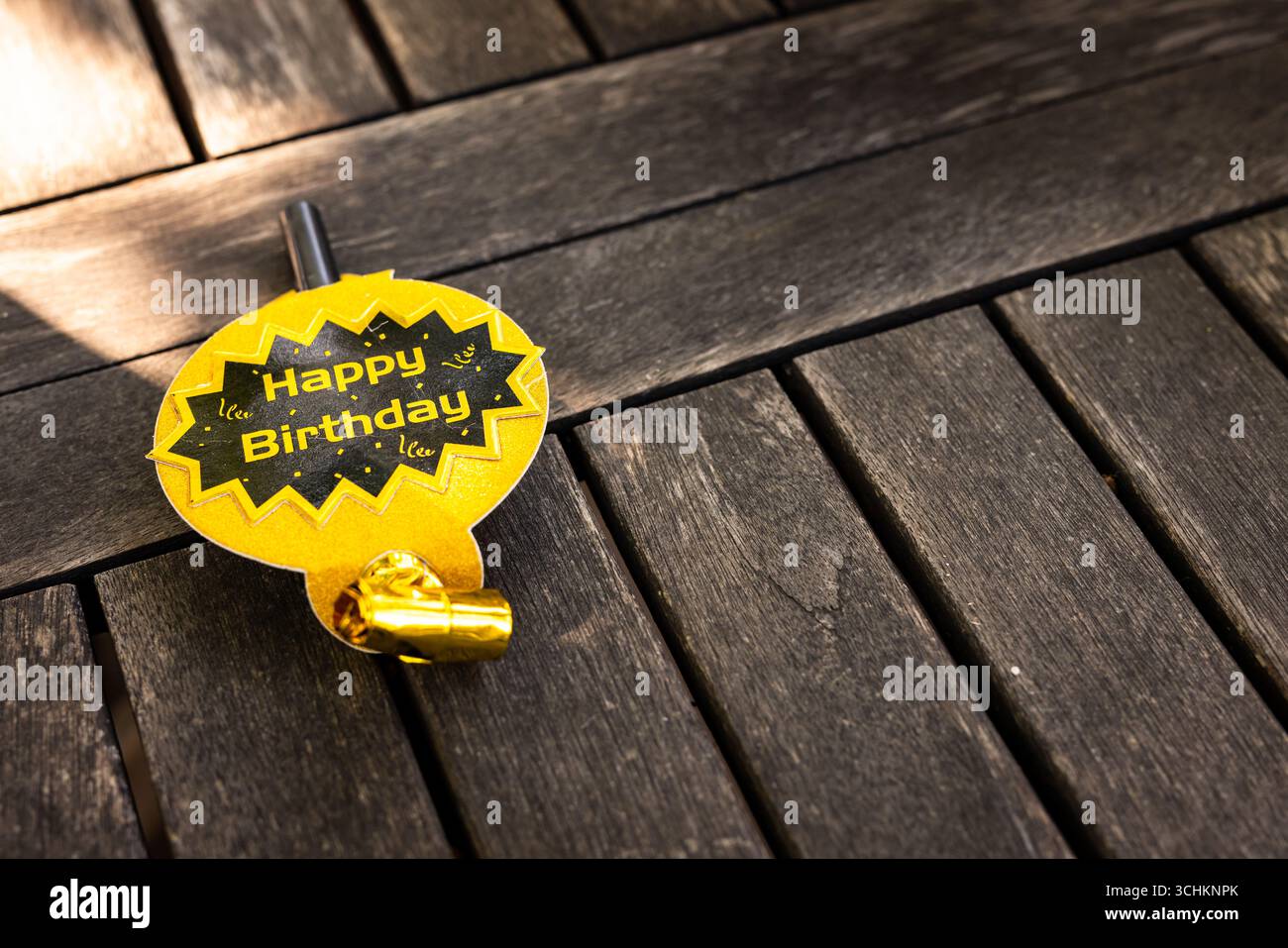 At party, birthday party badge on wooden table, ready for festive celebration, in garden, copy space Stock Photo