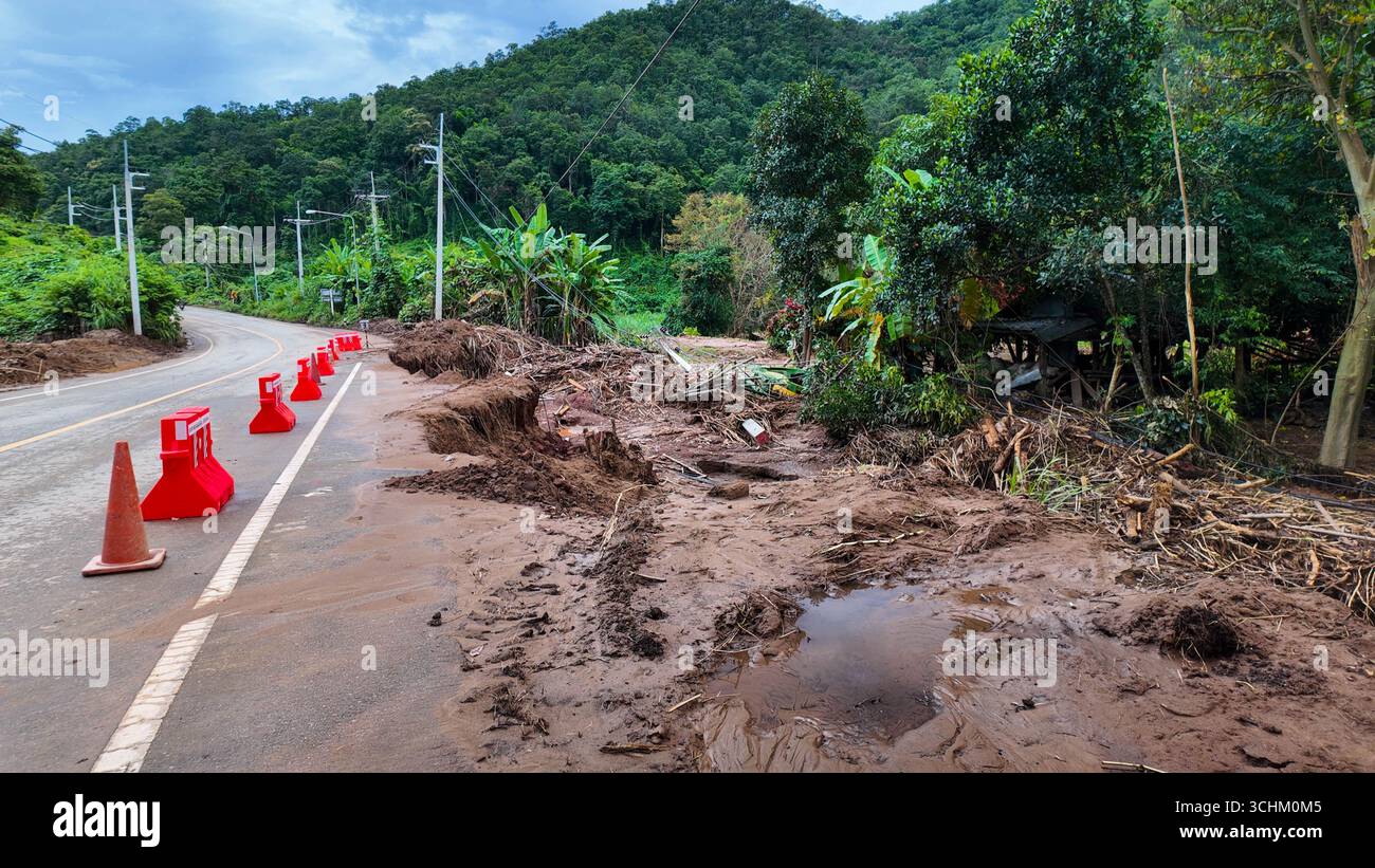 A damaged mountain road eroded by flood and landslide, with warning ...