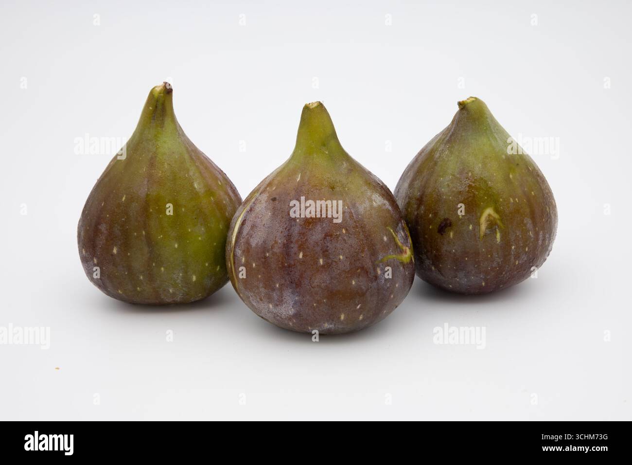 Three ripe figs on a white background. Stock Photo