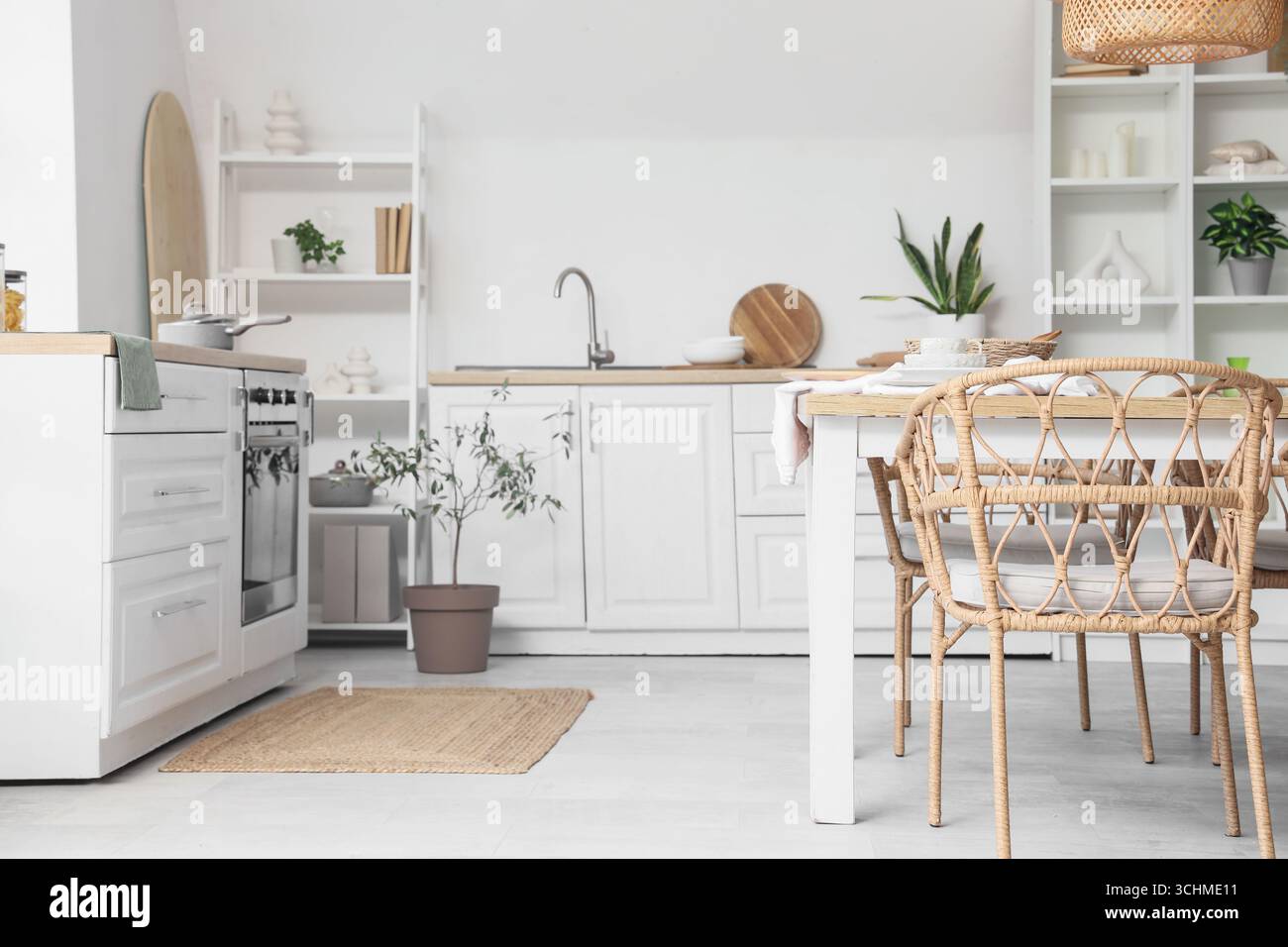 Interior of light kitchen with dining table, counters and shelf units ...
