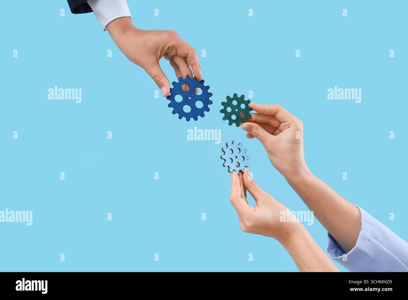 Hands with gears on blue background Stock Photo