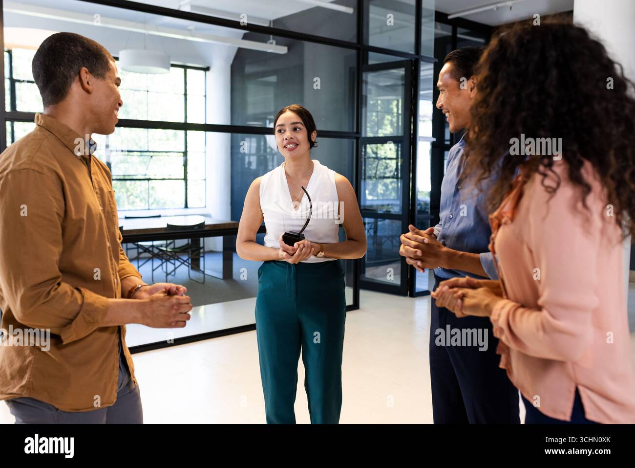 Diverse business team discussing project in modern office, smiling and engaged Stock Photo