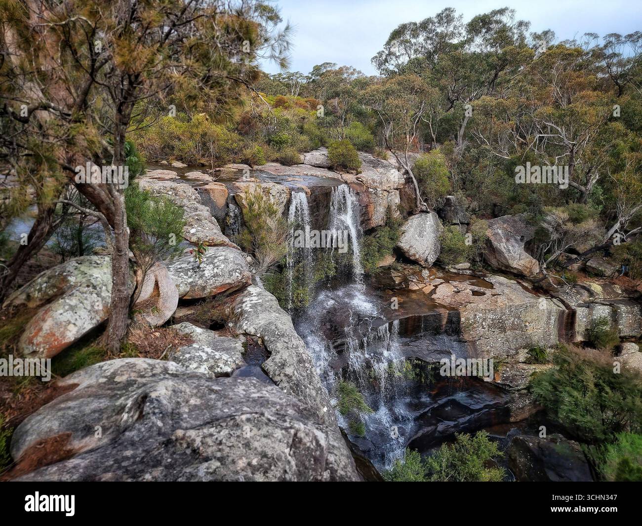 Waterfall flowing over rocky cliffs surrounded by forest in the Blue Mountains, New South Wales, Australia - Smartphone Captured Stock Image Waterfall flowing over rocky cliffs surrounded by forest in the Blue Mountains, New South Wales, Australia - Smartphone Captured Stock Image