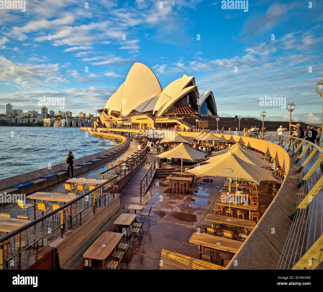 Sydney Opera House at Circular Quay with waterfront dining and boardwalk at sunset, New South Wales, Australia. - Smartphone Captured Stock Image