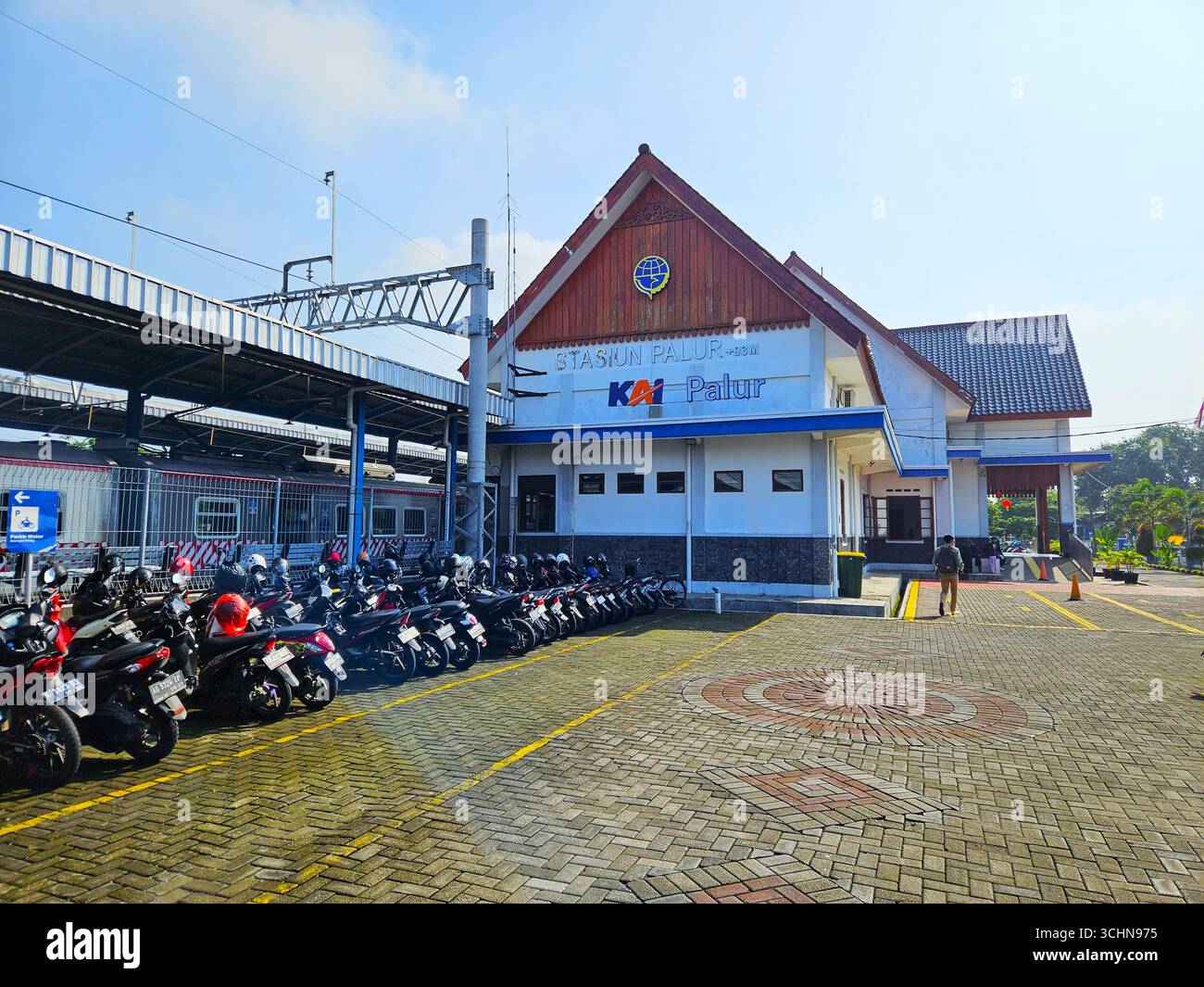 Palur train station building with motorcycles parked outside under clear blue sky. Solo, Indonesia - February 16th, 2024 - Smartphone Captured Stock Image