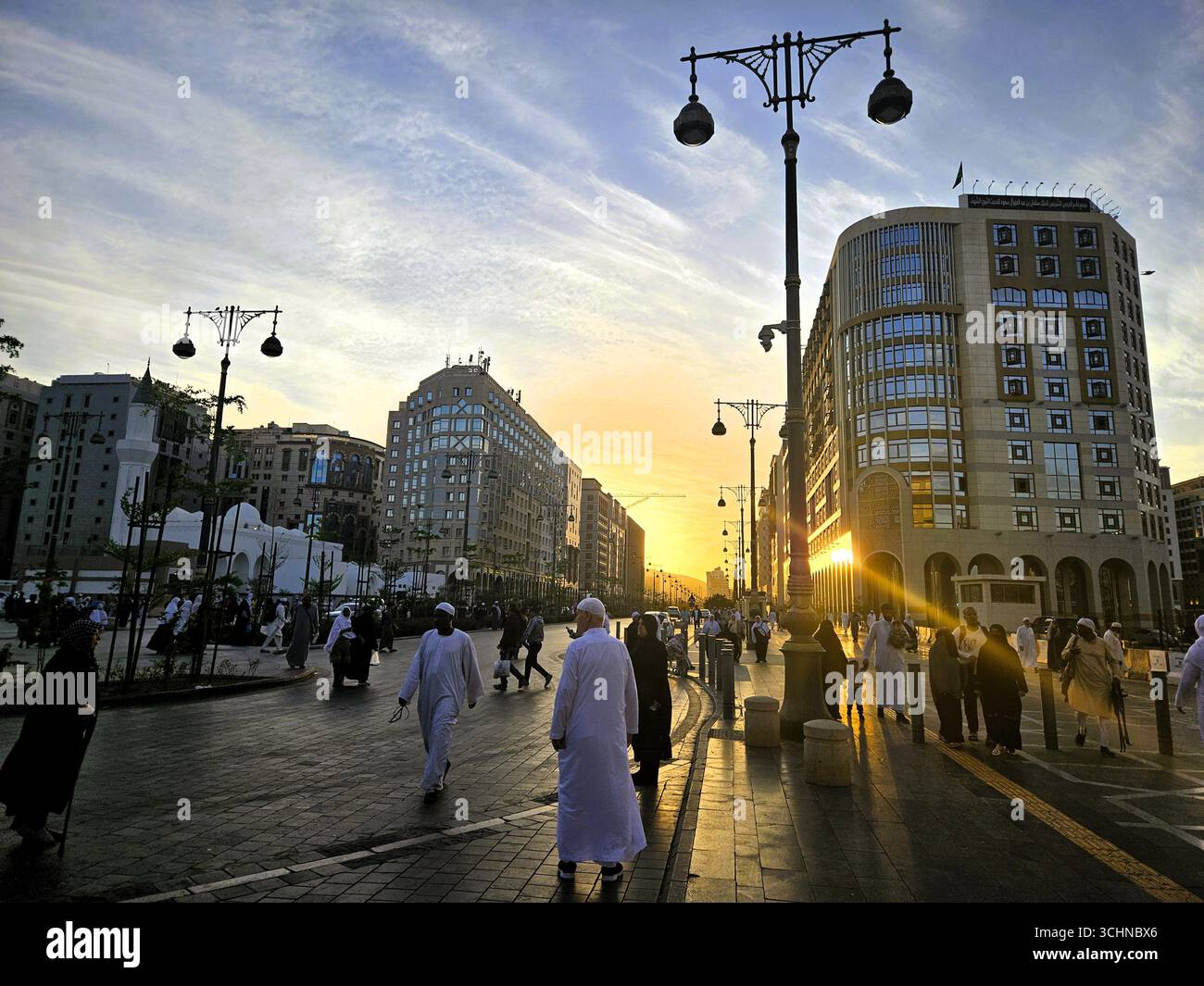 People on the streets enjoying the sunset in the city of Medina. Madinah, Saudi Arabia - March 6th, 2024 - Smartphone Captured Stock Image