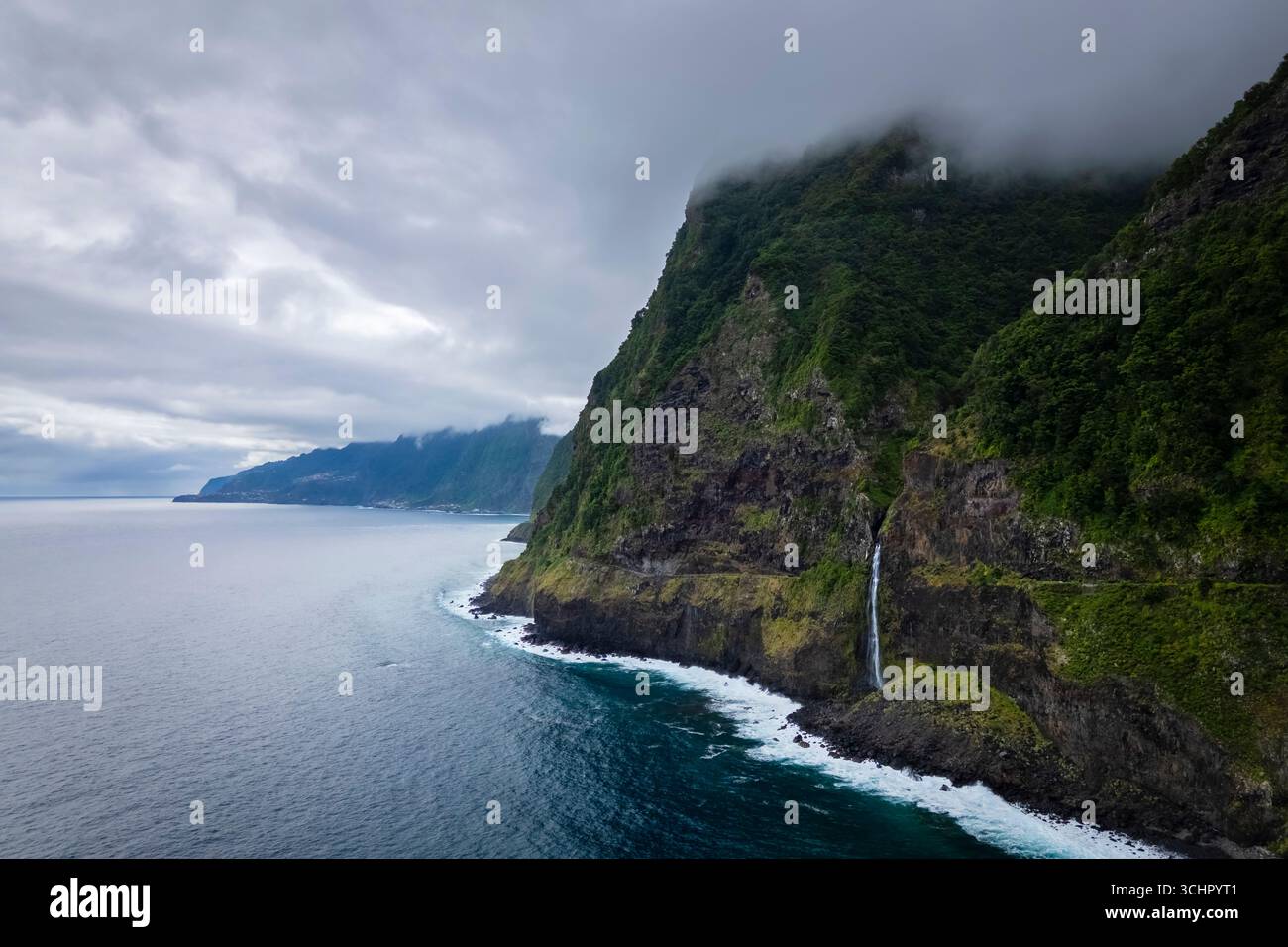 Aerial view of a waterfall going directly in the ocean on the coast of Seixal in spring. Madeira, Portugal, Europe. Stock Photo