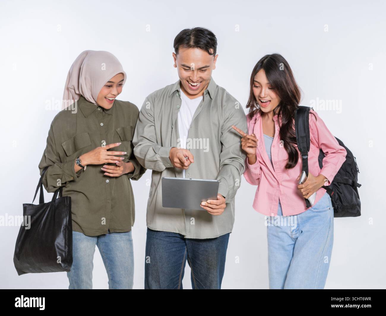 Young friends creatively collaborating with a tablet in a studio setting Stock Photo