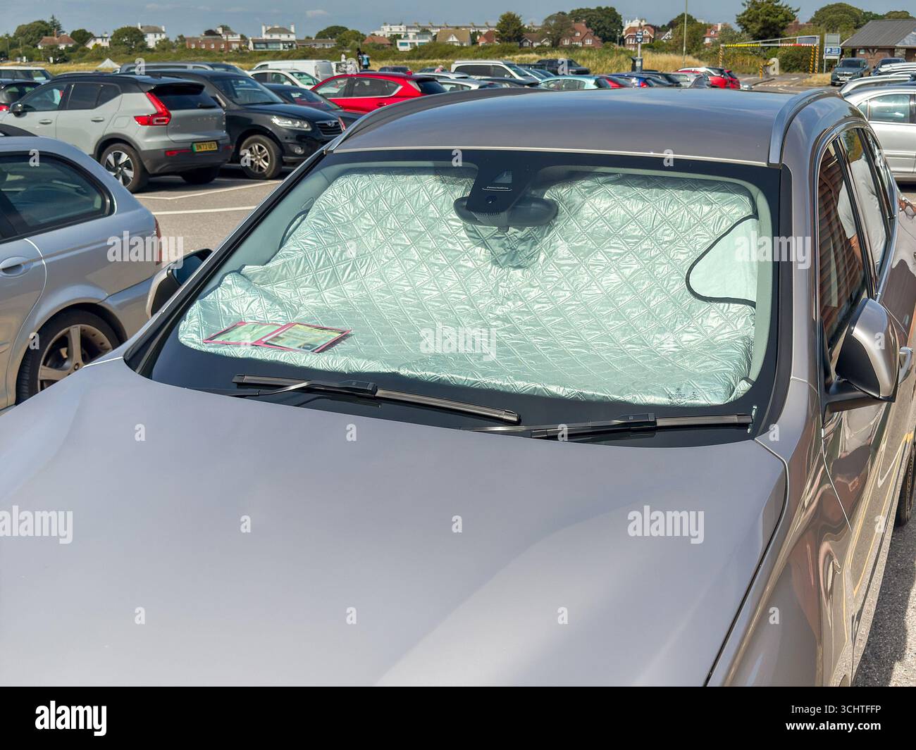 Gosport, Hampshire, England, UK - 28 June 2025: Reflective cover on the dashboard of a car to keep the interior cool on a hot day in summer. - Smartphone Captured Stock Image