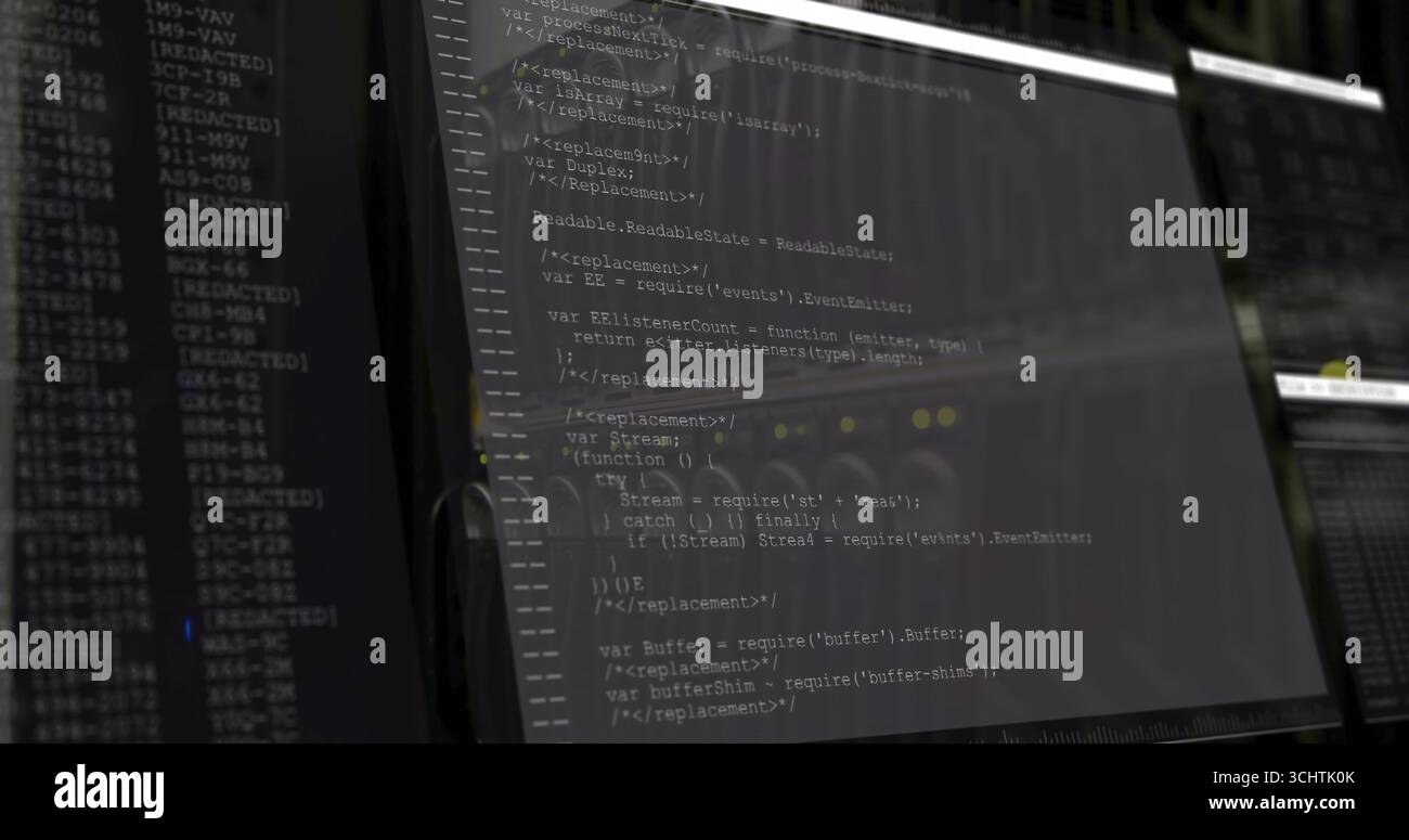 Displaying computer monitor presenting JavaScript code in dimly lit office, with secondary monitor Stock Photo