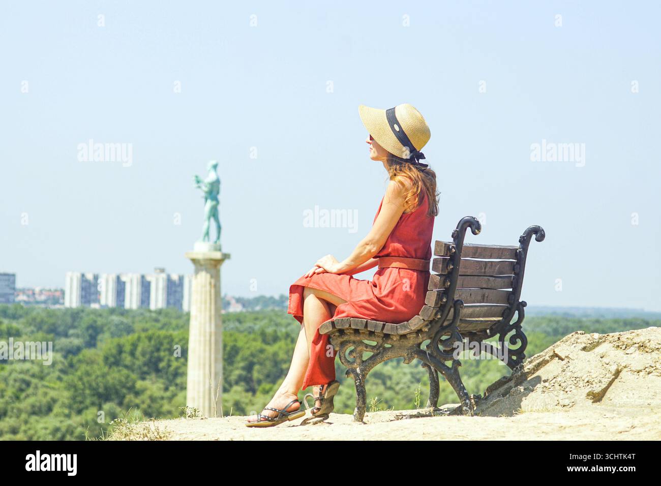 Woman relaxing on bench near famous Pobednik statue in Belgrade Serbia. Digital detox and slow travel lifestyle at historic fortress viewpoint Stock Photo