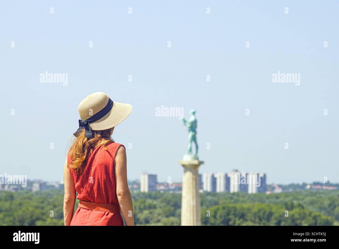Back view of woman exploring Belgrade fortress. Female tourist near Pobednik monument. Concept of slow travel, inspiration and mindful tourism Stock Photo