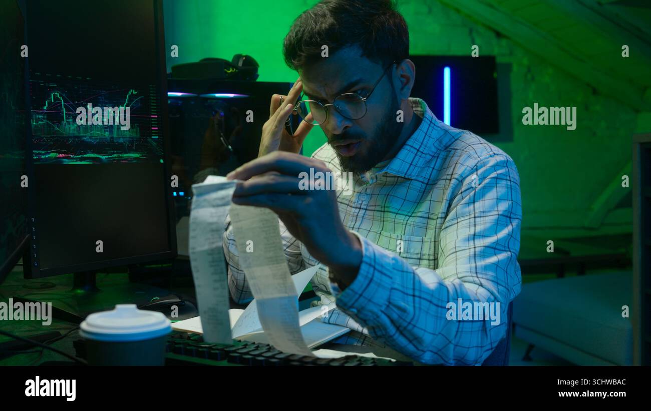 Arabian Indian man male guy programmer examining writing binary code coder freelancer engineer worker IT specialist monitor analyzing computer Stock Photo