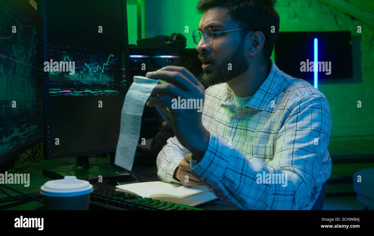 Arabian Indian man male guy programmer examining writing binary code coder freelancer engineer worker IT specialist monitor analyzing computer Stock Photo