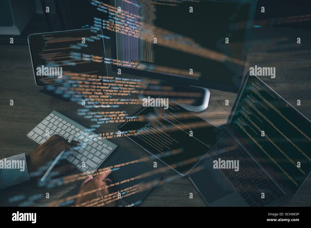 Coding and software development concept, with programmer typing on keyboard surrounded by laptop, tablet, and monitor showing glowing source code line Stock Photo