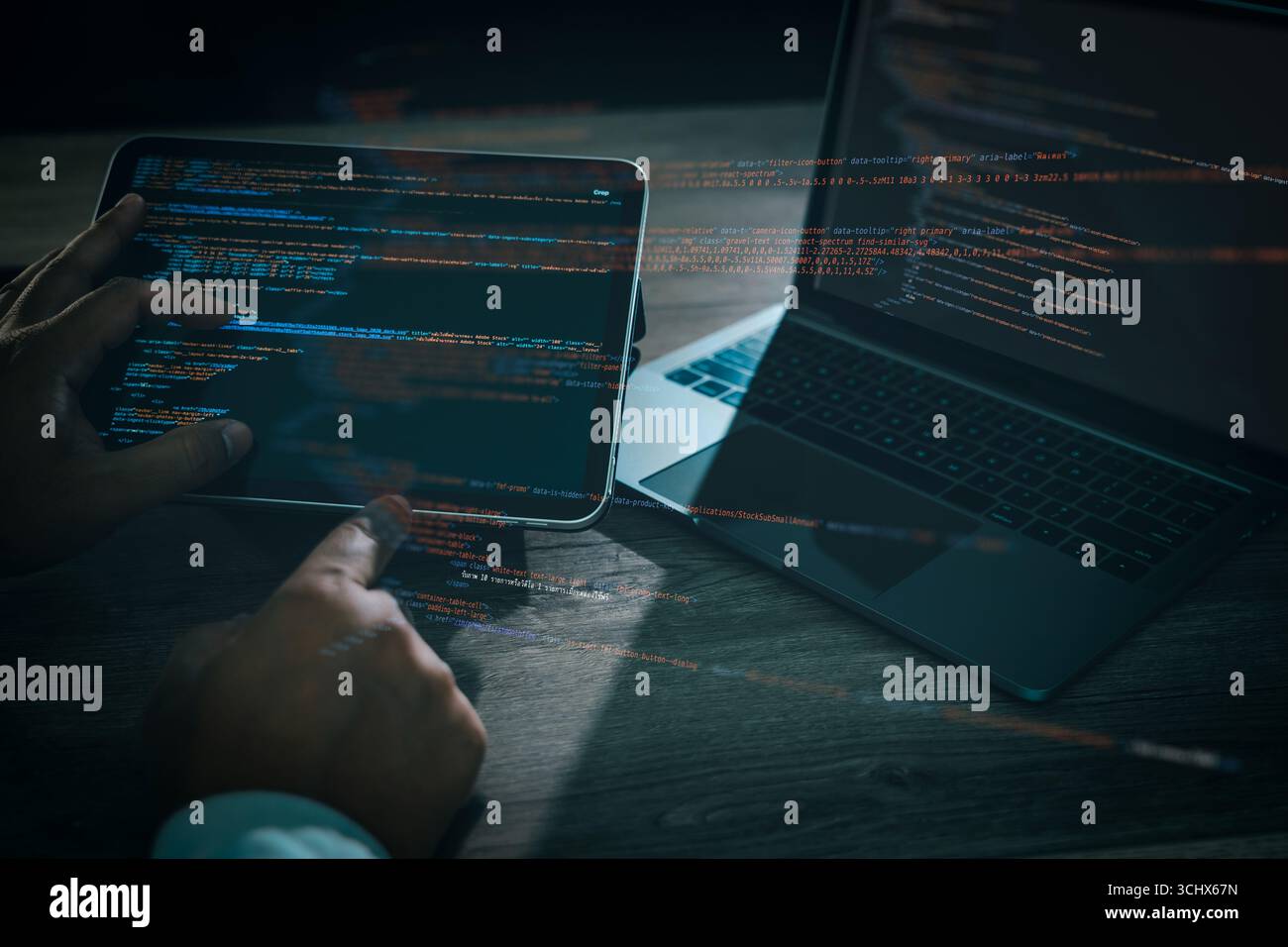 Programmer coding software on tablet and laptop with glowing lines of code, concept of programming, web development, cybersecurity, data technology, a Stock Photo