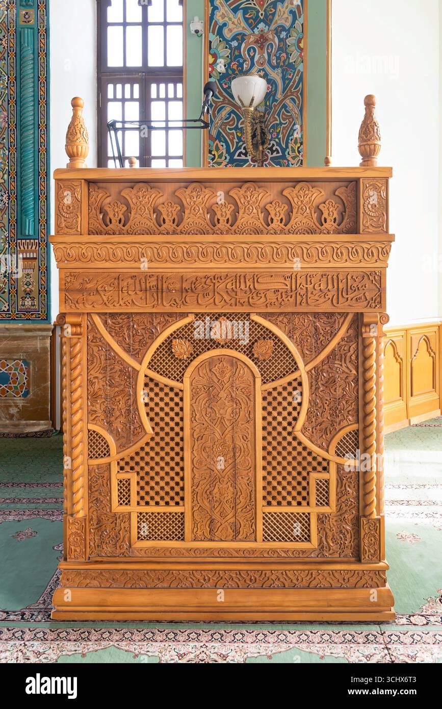 Ornate carved wooden minbar with intricate Islamic patterns and Arabic ...